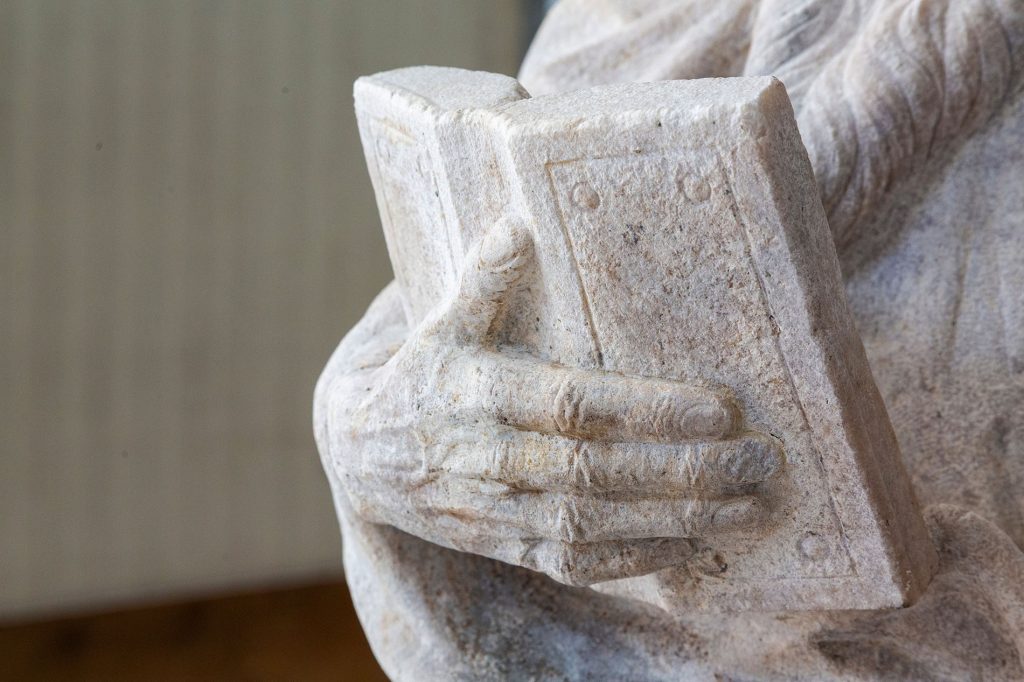 Dettaglio della scultura (libro) raffigurante Santo barbuto con libro, dopo le operazioni di restauro, all'interno del progetto di donazioni 2Adotta una Statua"