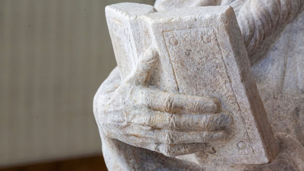 Dettaglio della scultura (libro) raffigurante Santo barbuto con libro, dopo le operazioni di restauro, all'interno del progetto di donazioni 2Adotta una Statua"